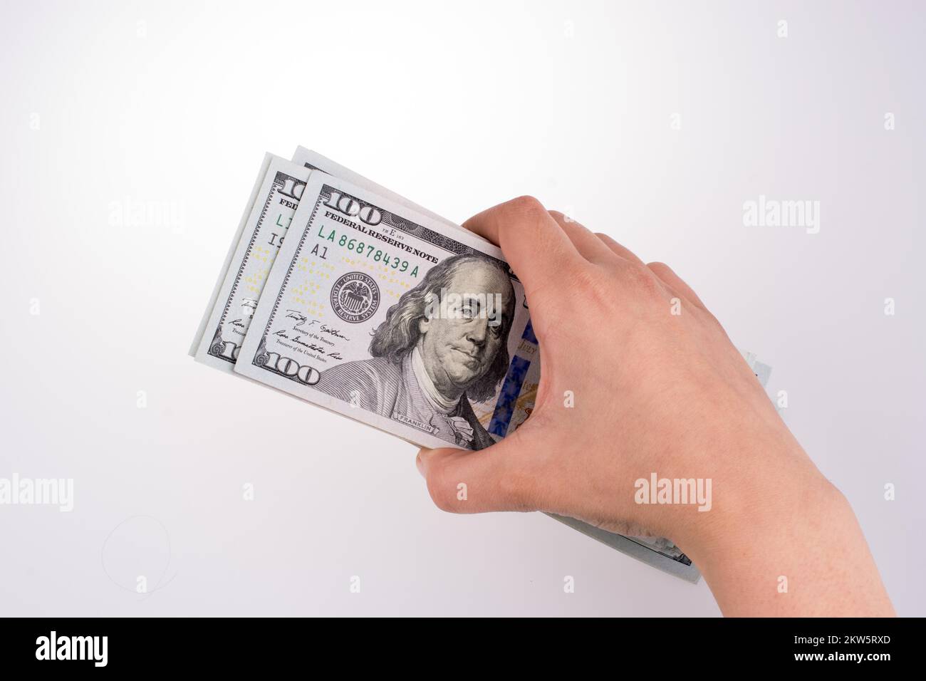 Mano umana tenendo dollaro americano Bill come denaro isolato su bianco Foto Stock
