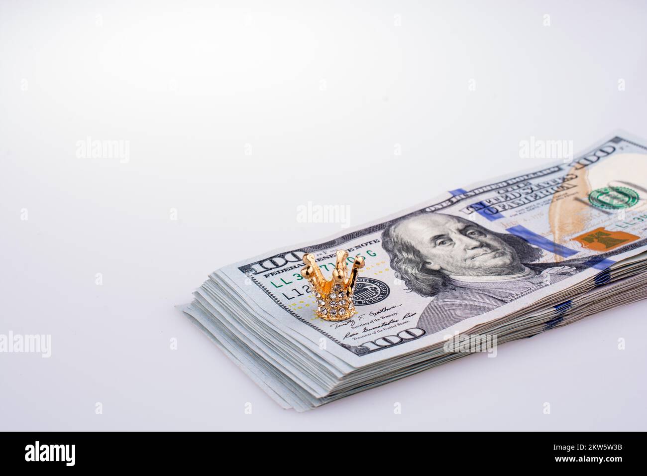 Banconote americane da 100 dollari e una corona color oro Foto Stock