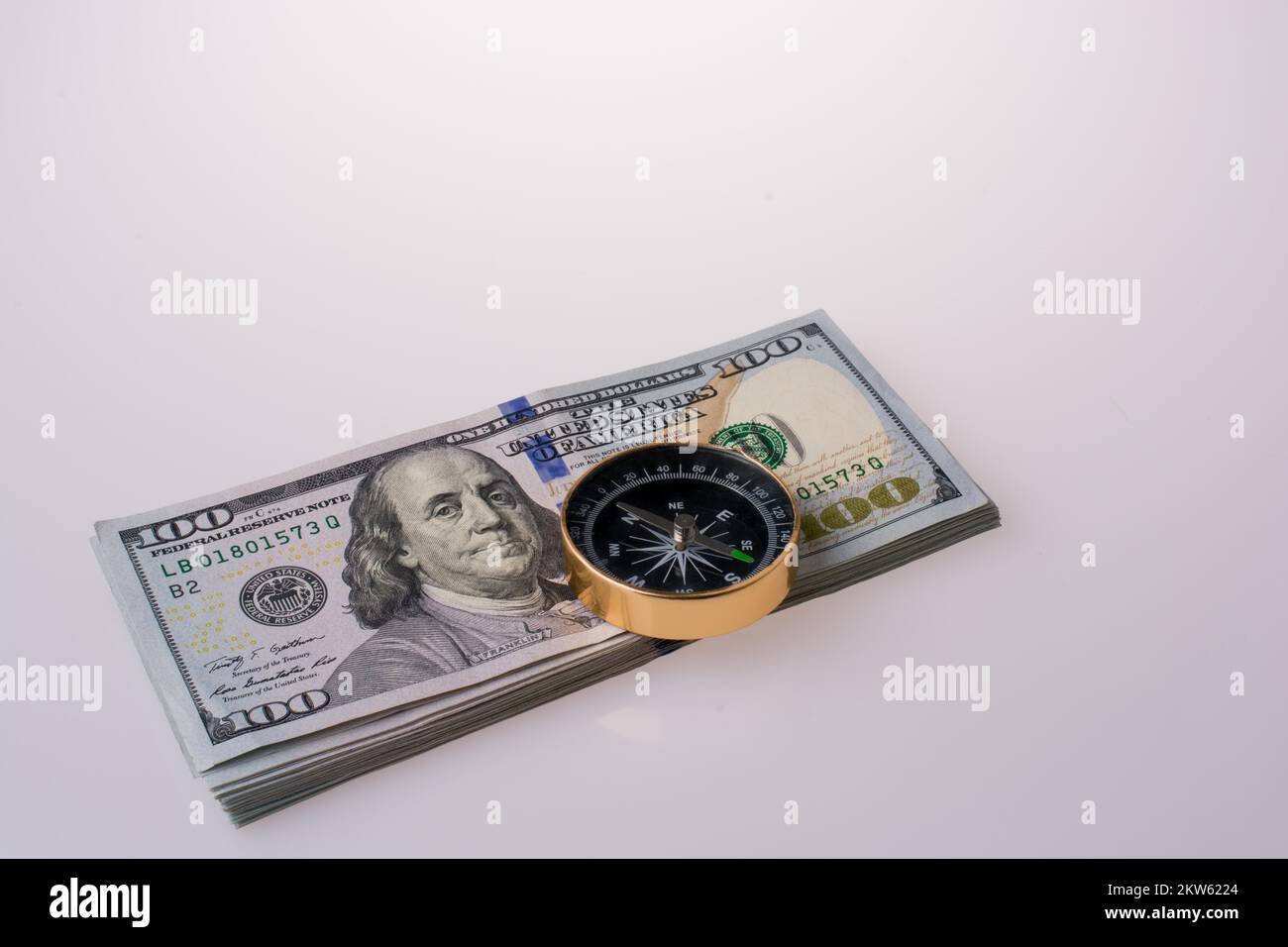 Dollaro americano banconote su una bussola su sfondo bianco Foto Stock