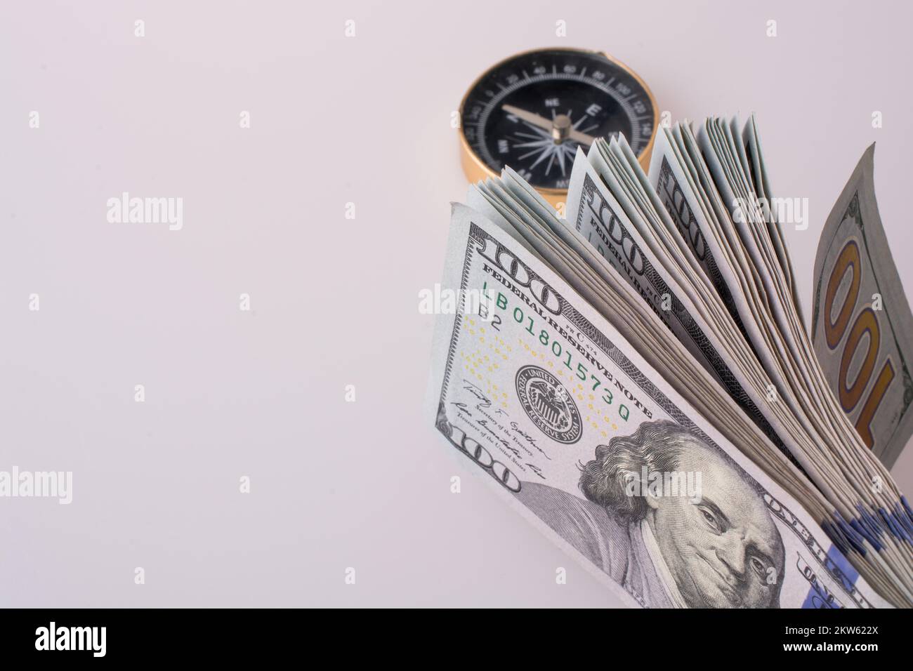Dollaro americano banconote dal lato di una bussola su sfondo bianco Foto Stock