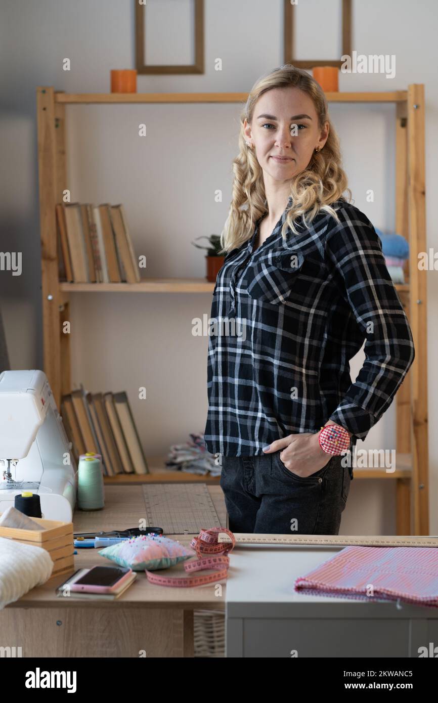 Ritratto di donna comò, stilista, sarto o marinaio in studio. Donna sorridente che guarda la macchina fotografica al suo posto di lavoro in studio di cucito. COP Foto Stock