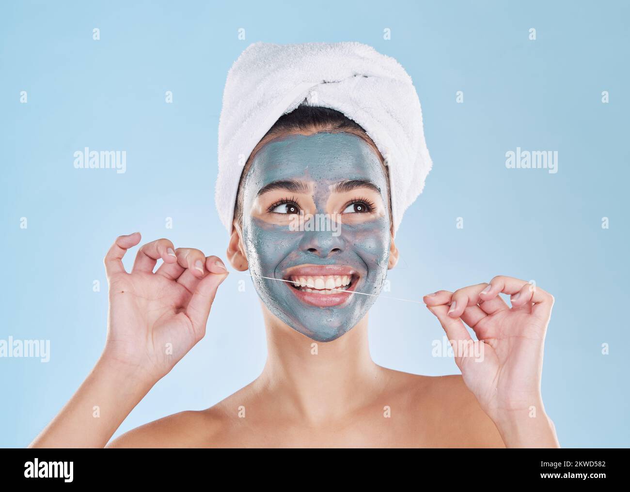 Maschera per la cura della pelle, cura dei capelli o filo interdentale nel governare, bellezza indaffarata e benessere studio su sfondo blu. Sorridere, faccia felice o rilassare donna con fango Foto Stock