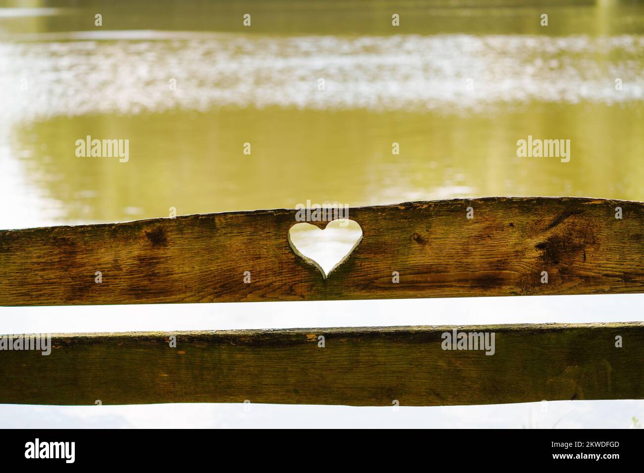 Cuore scolpito in legno su uno schienale. Lago sullo sfondo. Foto Stock