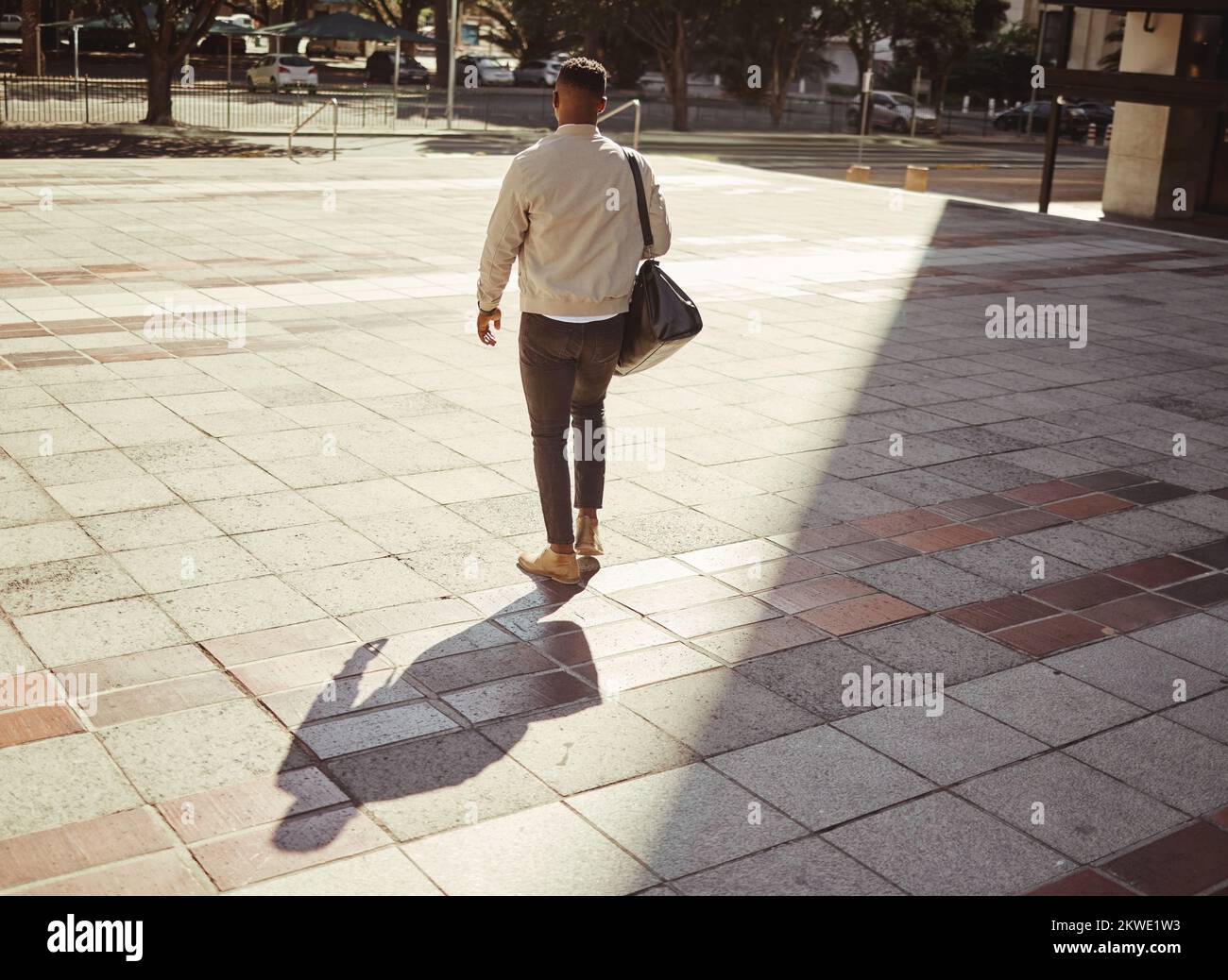Affari, viaggi e città con un giovane uomo che cammina all'aperto su un sfondo urbano durante il giorno. Imprenditore o dipendente in cerca di lavoro, un lavoro Foto Stock