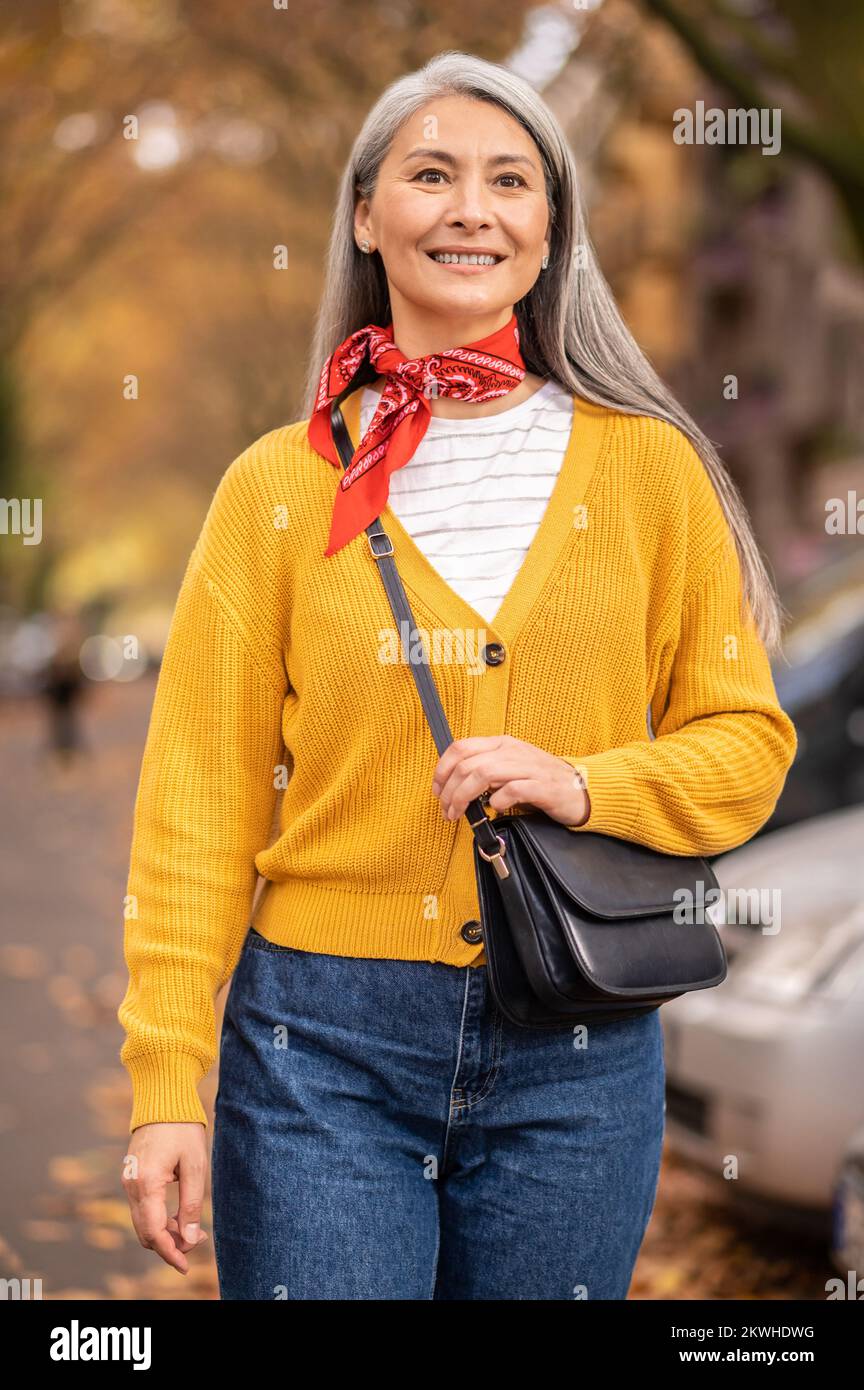 Donna dai capelli lunghi che cammina in un parco autunnale Foto Stock