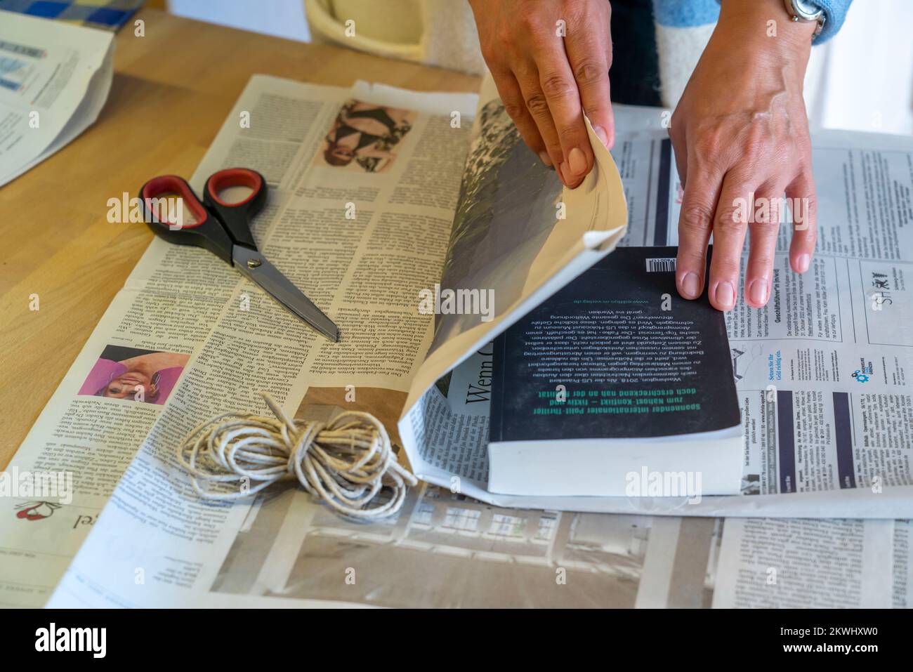 Confezione regalo sostenibile, su giornale, senza nastro adesivo, solo legato con cordino, Foto Stock