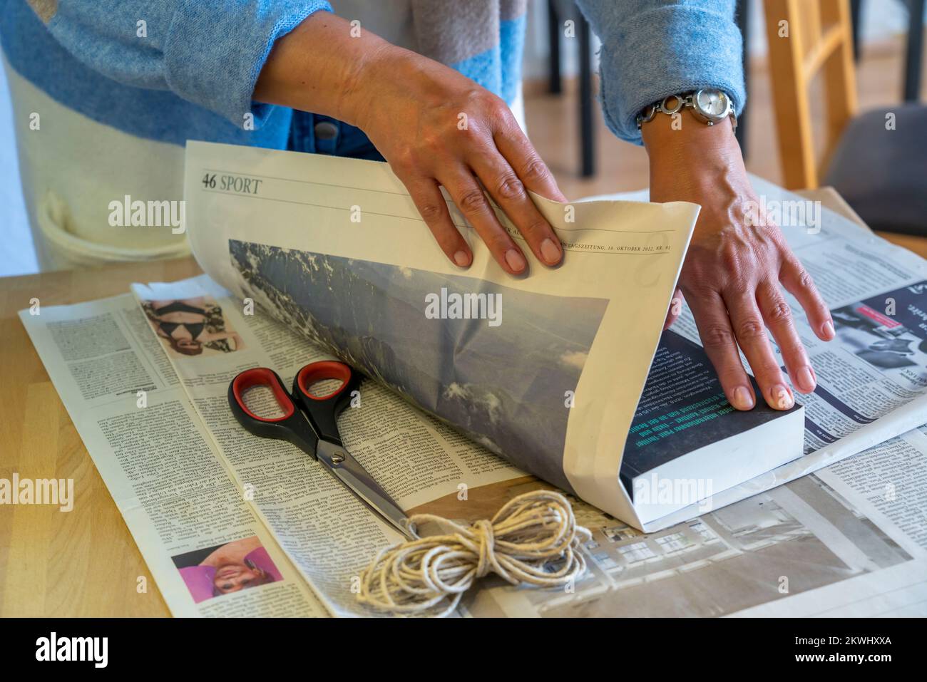 Confezione regalo sostenibile, su giornale, senza nastro adesivo, solo legato con cordino, Foto Stock