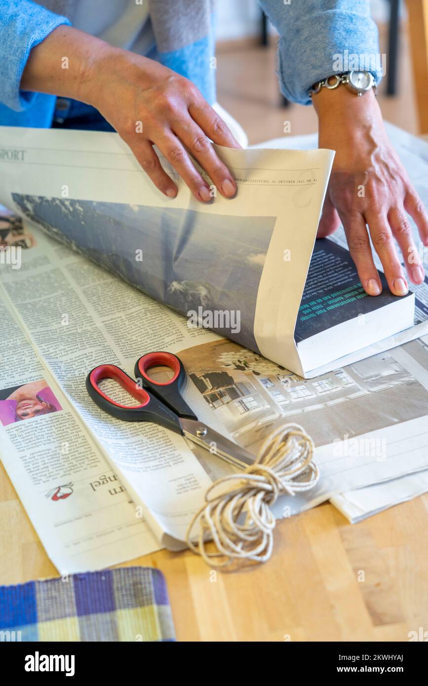 Confezione regalo sostenibile, su giornale, senza nastro adesivo, solo legato con cordino, Foto Stock