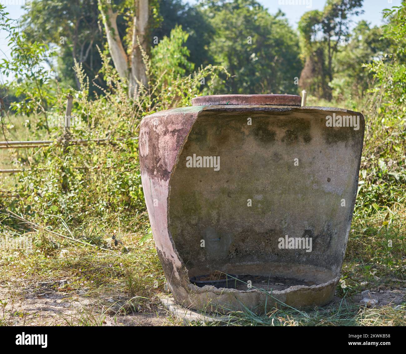 Un grande vaso d'acqua danneggiato tradizionale sulla fattoria na nella Thailandia rurale. Foto Stock
