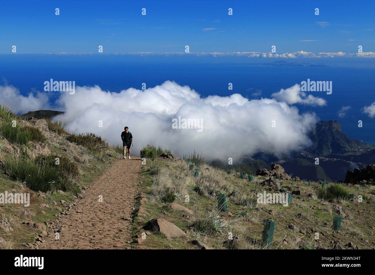 Uomo che cammina sentiero sopra l'inversione di nuvola a Pico do Arieiro, Madeira Foto Stock