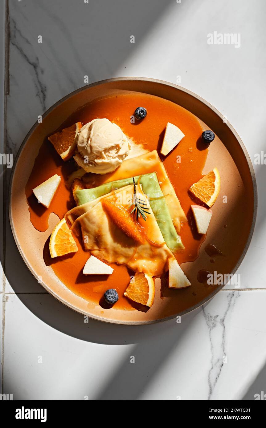 Crepes con gelato alla vaniglia, salsa d'arancia e arance fresche Foto Stock
