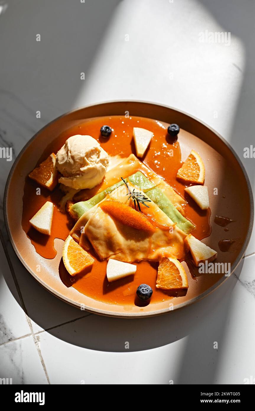 Crepes con gelato alla vaniglia, salsa d'arancia e arance fresche Foto Stock