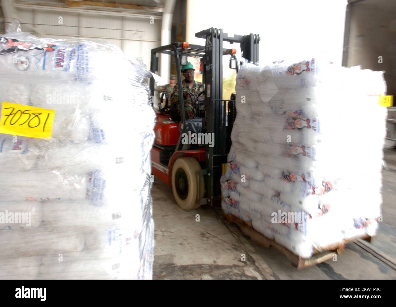 Hurricane Wilma, Homestead, FL, 30 ottobre 2005 i guardiani nazionali spostano pallet di ghiaccio in un appendiabiti presso la base dell'aeronautica che viene utilizzata come area di sosta per la distribuzione di acqua e ghiaccio per le aree colpite dall'uragano Wilma. Jocelyn Augustno/FEMA.. Fotografie relative a disastri e programmi, attività e funzionari di gestione delle emergenze Foto Stock