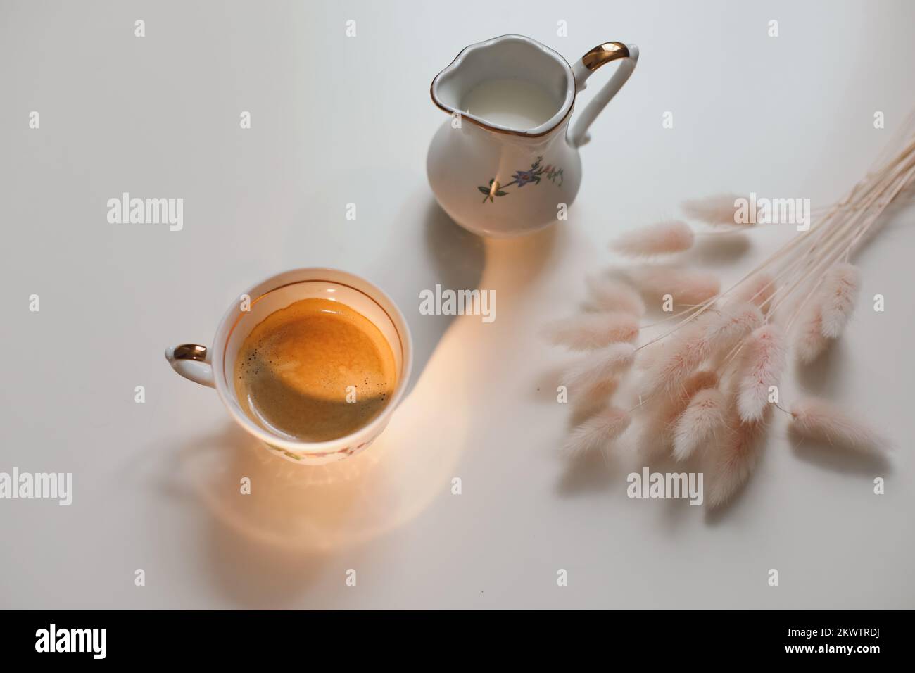 tazza con caraffa per caffè e latte su sfondo di legno bianco, primo piano. Colazione energetica, concetto di routine mattutina Foto Stock