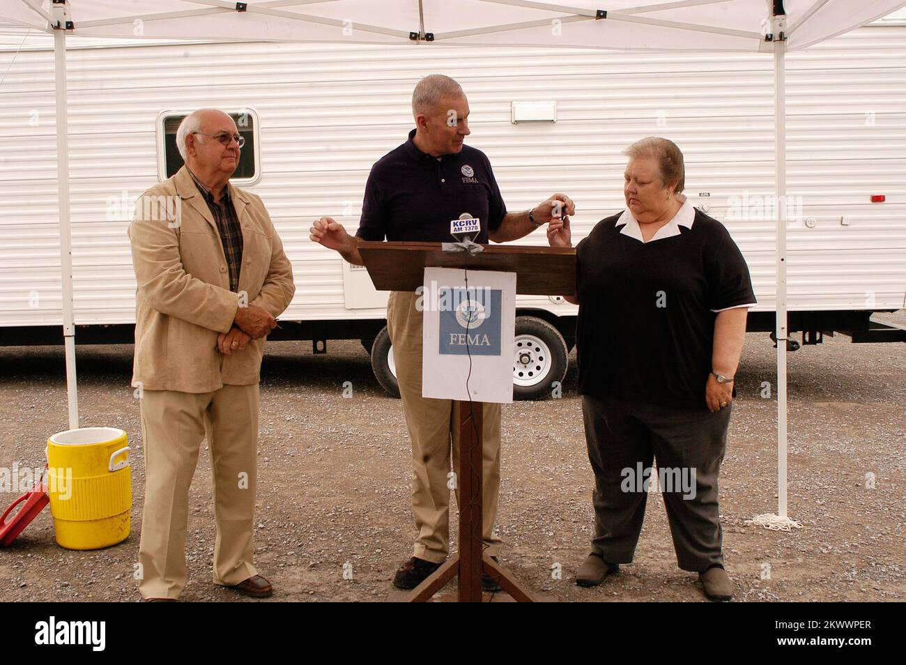 Gravi tempeste, tornado, ed alluvioni, Caruthersville, Missouri, 4-20-06 FCO Tom Costello consegna al sindaco Diane Sayre di Caruthersville, MO la chiave per una nuova casa FEMA fabbricata come presidente del commissario, Charle Mass, guarda avanti. Sia Sayre che Mass hanno poi presentato le chiavi ai residenti che hanno perso le case quando un tornado ha colpito la città il 2 aprile 2006.. Fotografie relative a disastri e programmi, attività e funzionari di gestione delle emergenze Foto Stock