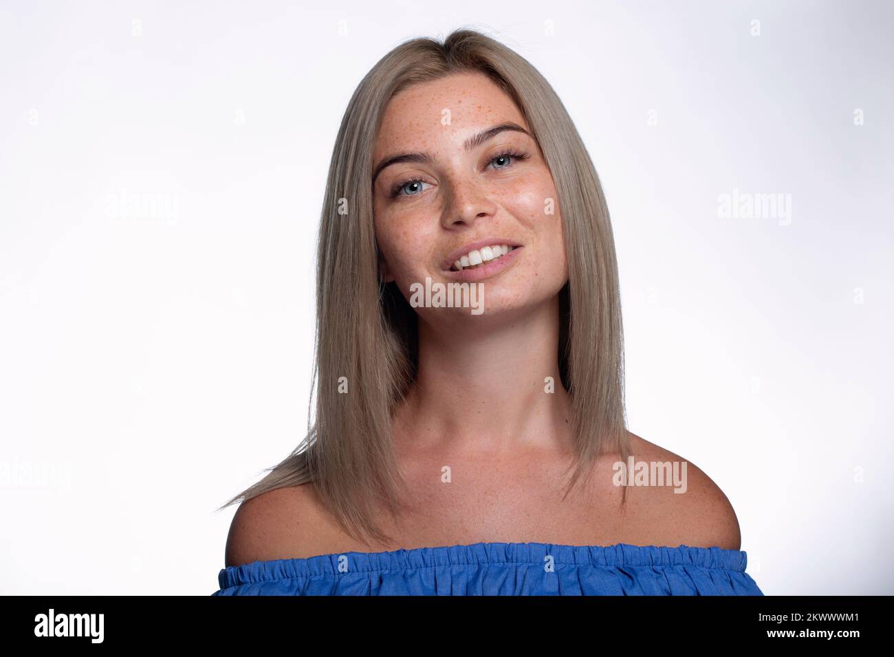 Bella ragazza con freckles mostra le emozioni di fronte al fotocamera su sfondo bianco Foto Stock