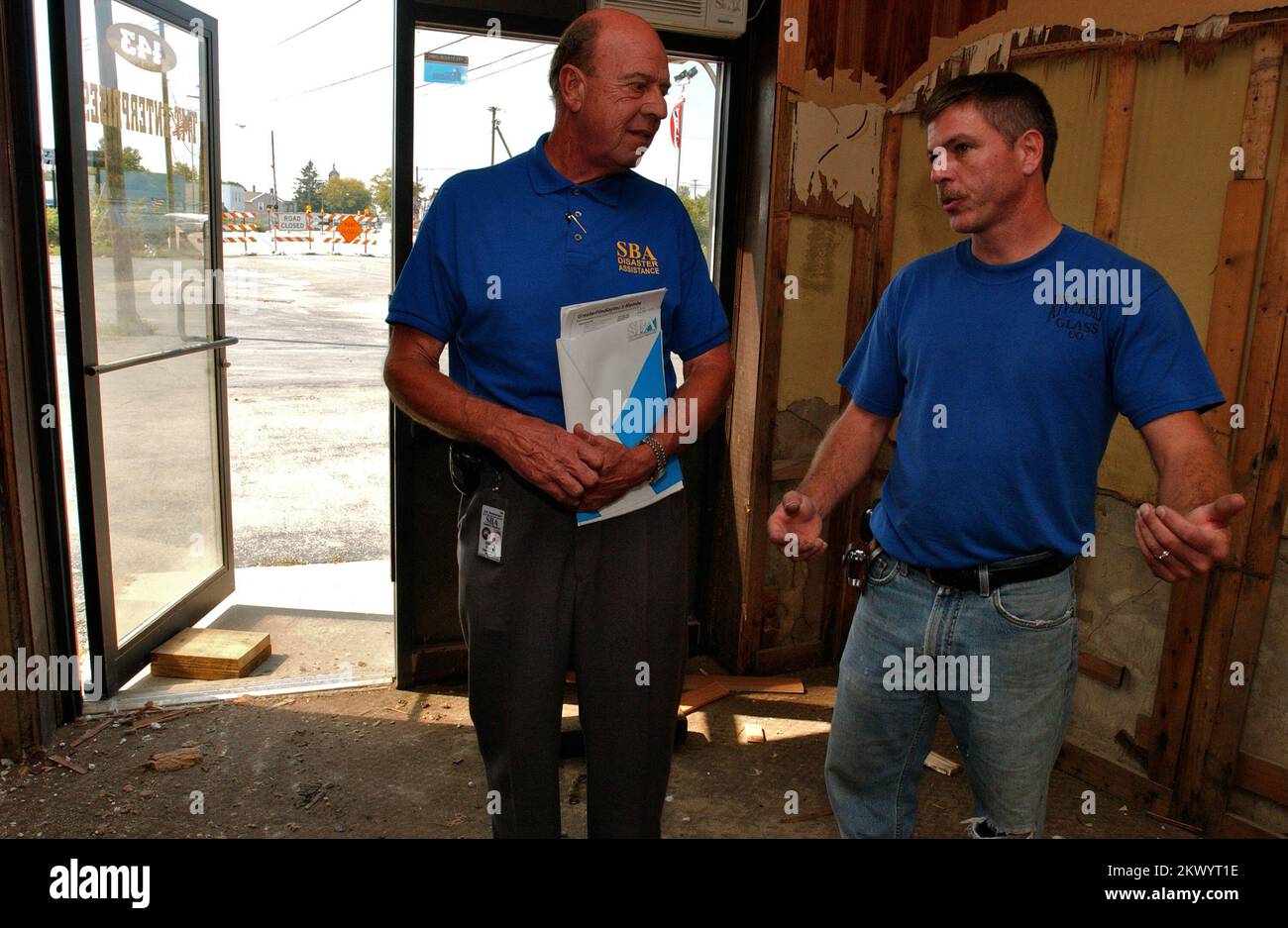 Tempeste severe, inondando, e tornadoes, Findlay, Ohio, 20 settembre 2007 il rappresentante della Small Business Administration (SBA) Gilbert YingLing (L) ascolta Brian Wilkins, un imprenditore locale la cui azienda di vetro ha subito gravi danni nel recente alluvione. SBA contatta i proprietari di aziende locali come parte del programma Disaster Outreach. John Ficara/FEMA.. Fotografie relative a disastri e programmi, attività e funzionari di gestione delle emergenze Foto Stock