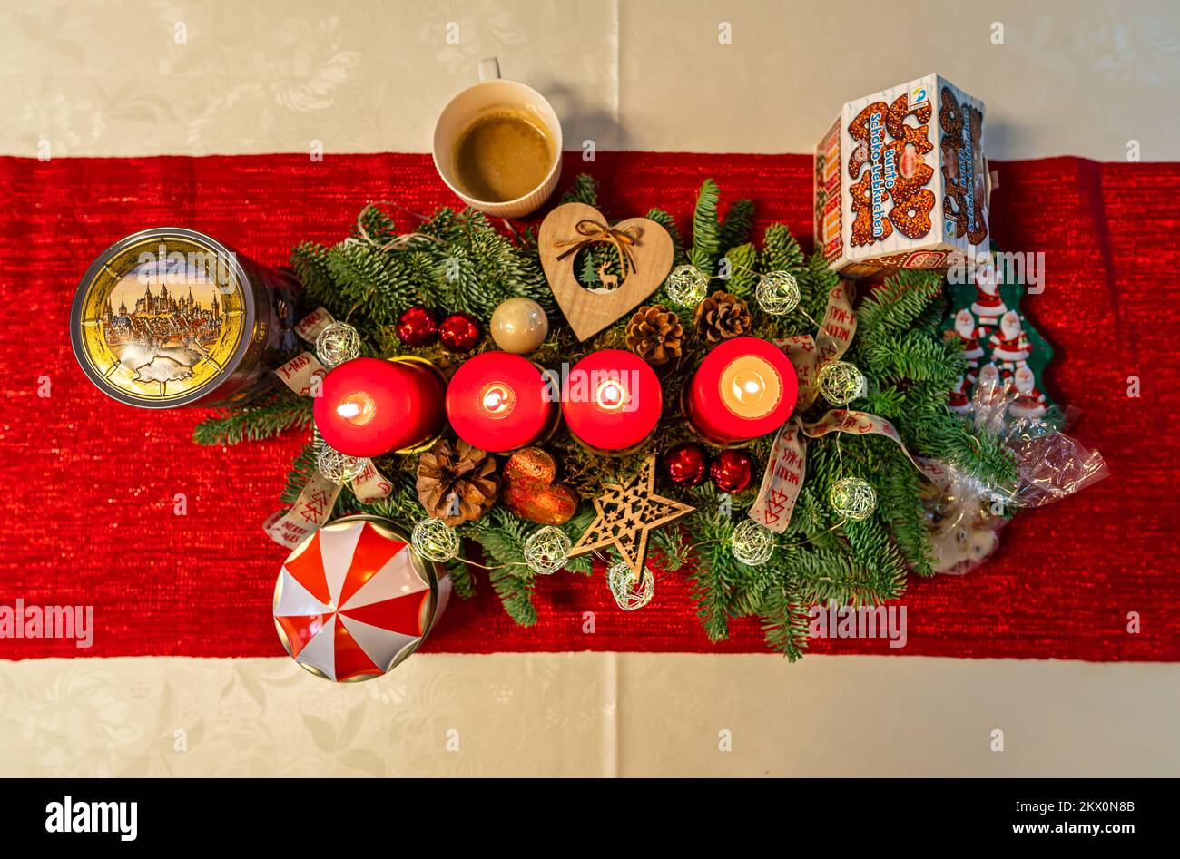 Quattro candele accese su una bella decorazione degli avventi si erodono da una vista dall'alto verso il basso. Foto Stock