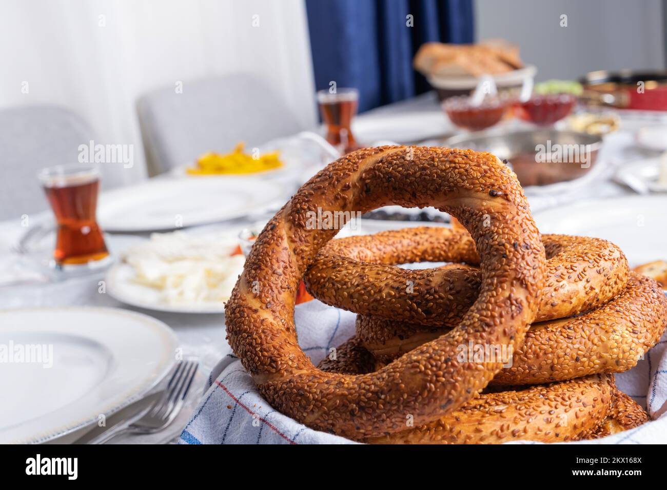 Primo piano foto del bagel Turco chiamato simit. Tradizionale ricco tavolo da colazione con formaggio, bicchiere di tè, salsiccia chiamato sucuk, marmellata, patate fritte. Foto Stock