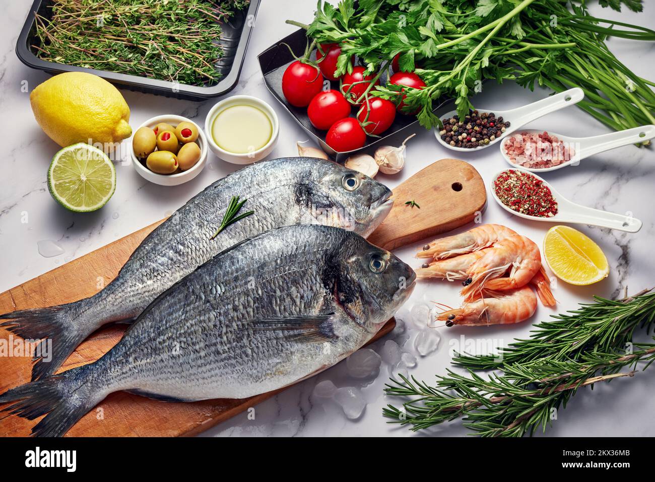 Pesce fresco cibo sfondo. Diversi frutti di mare, gamberetti e caviale rosso. Pesce per cucinare con erbe, verdure e spezie isolate su sfondo bianco Foto Stock