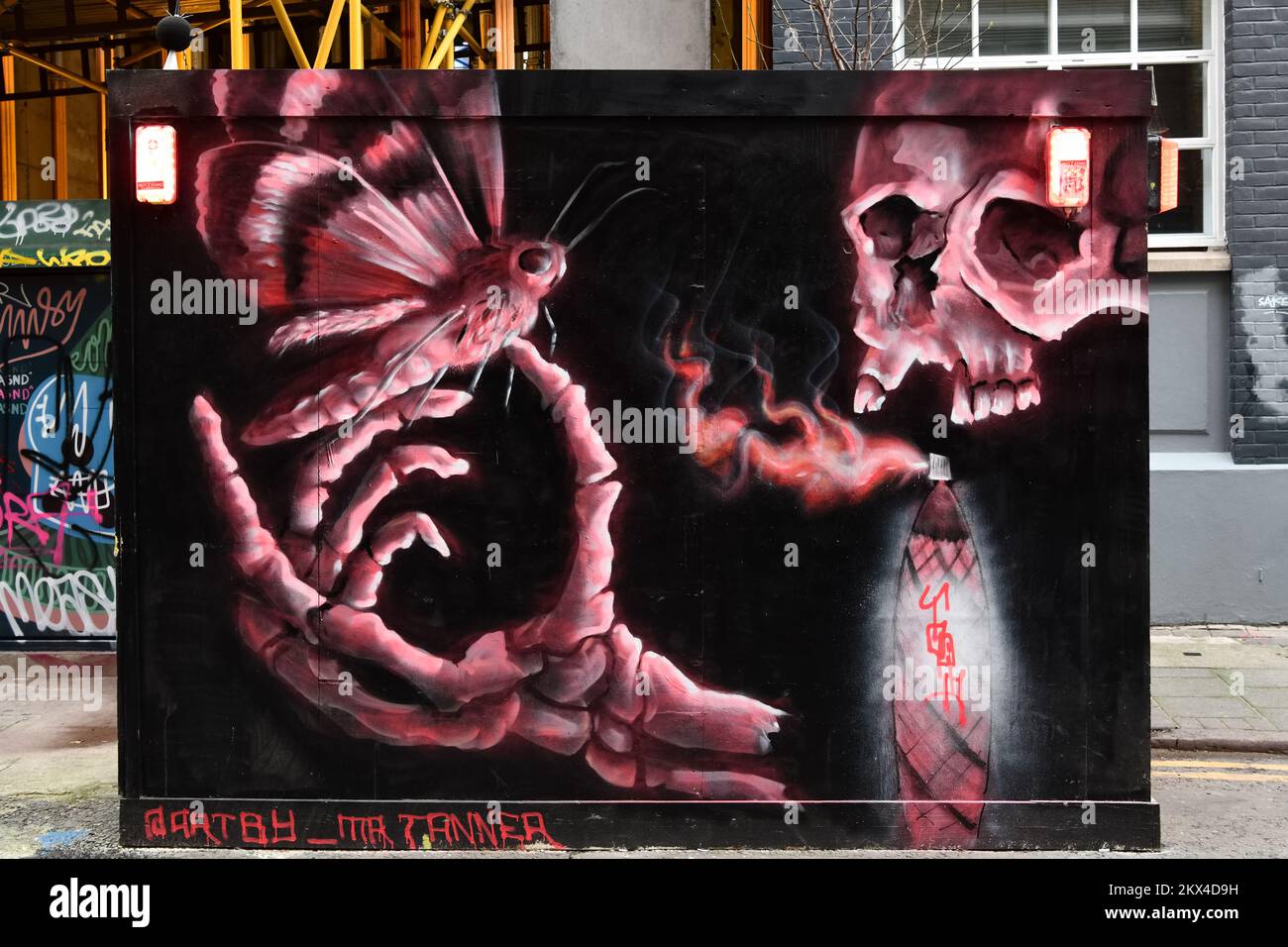 Street art di Matt Tanner comprendente cranio rosa e ossa di mano con la falena in Rivington Street, Shoreditch, Londra Foto Stock