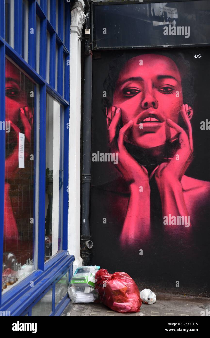 Street art ritratto di giovane donna sul lato dell'edificio con riflessione in finestra, Curtain Road, Shoreditch Londra Foto Stock