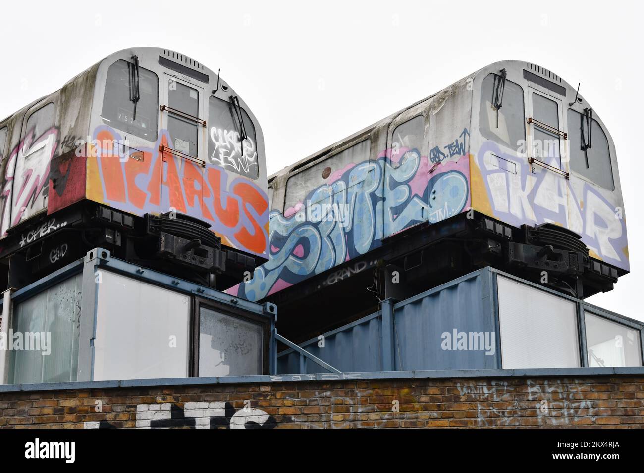 Due treni della metropolitana con graffiti e parole Icarus e Ikar in cima ad un edificio sulla Great Eastern Street a Shoreditch London Foto Stock