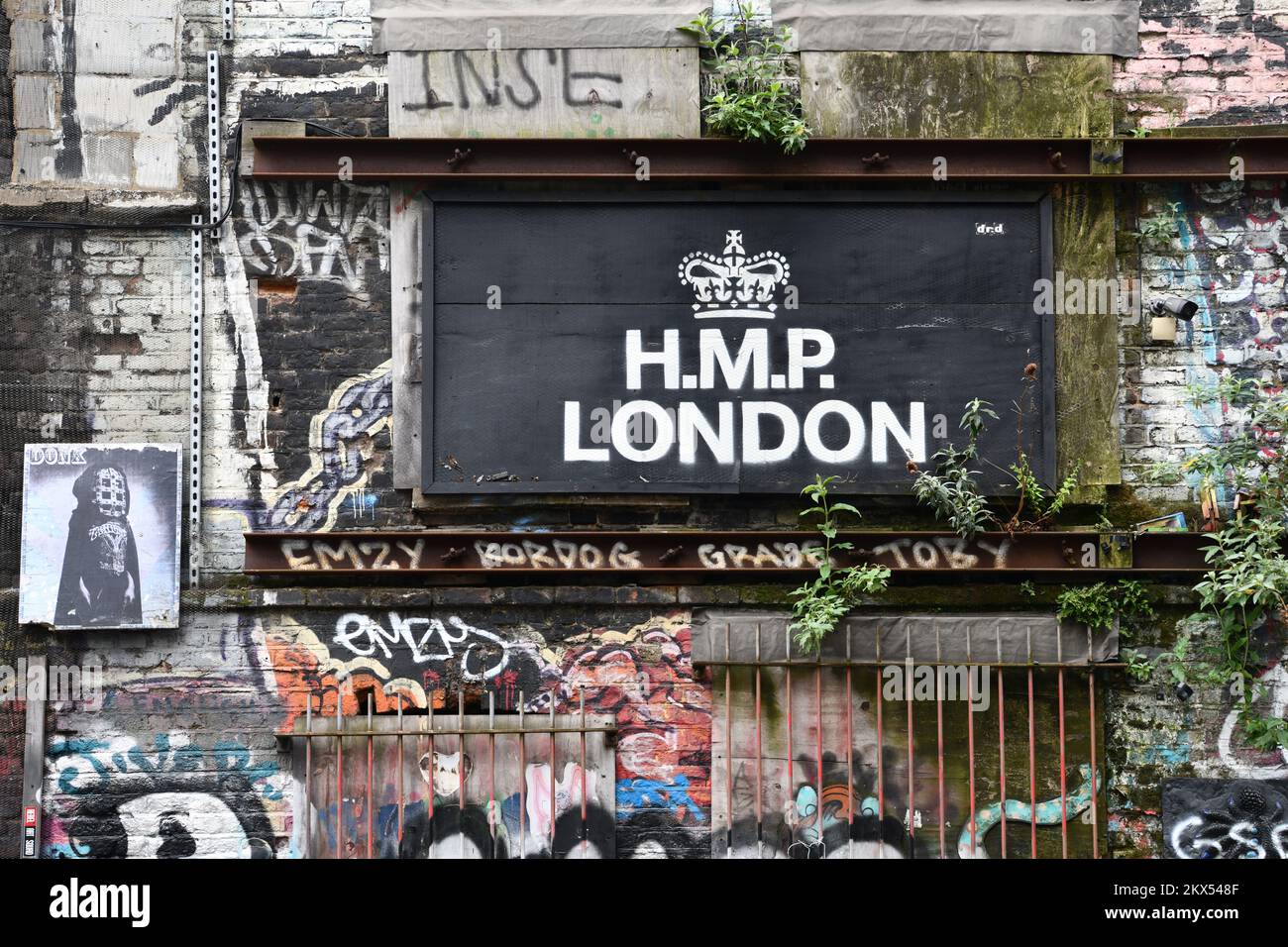 Muro di edificio derelitto in Sclater Street, Shoreditch, Londra con segno che dice HMP Prison London Foto Stock