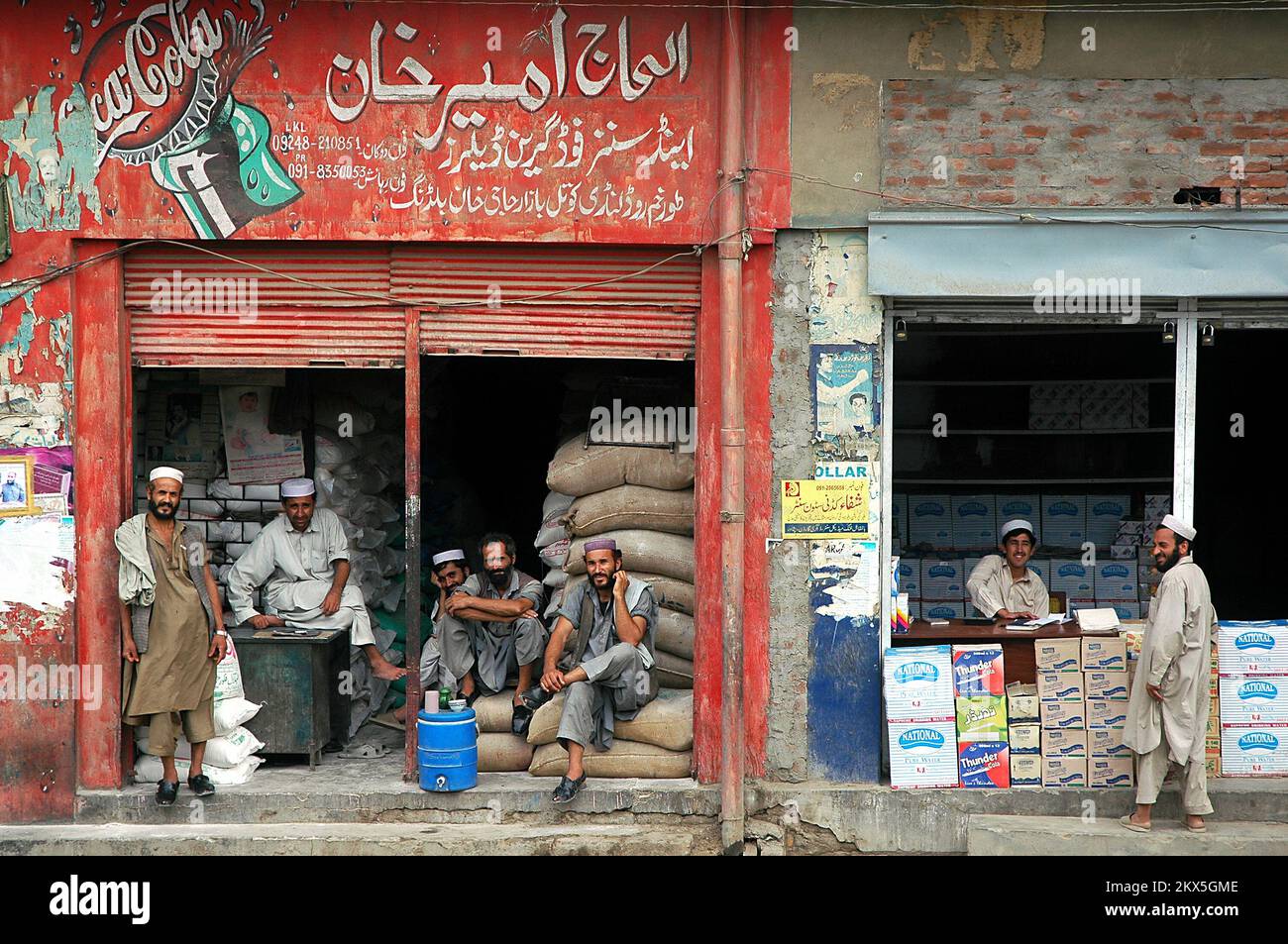 Landi Kotal, Passo Khyber, Khyber Pakhtunkhwa / Pakistan: Uomini musulmani locali al di fuori di due negozi a Landi Kotal, Pakistan. Foto Stock