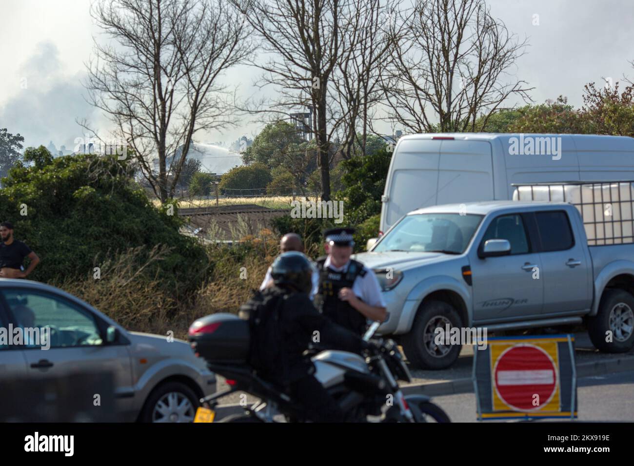 Il fumo da un incendio è visto come una chiusura della strada è in atto a Wennington, Londra est. Il Regno Unito ha registrato temperature superiori a 40 gradi per la 1st volta. Foto Stock