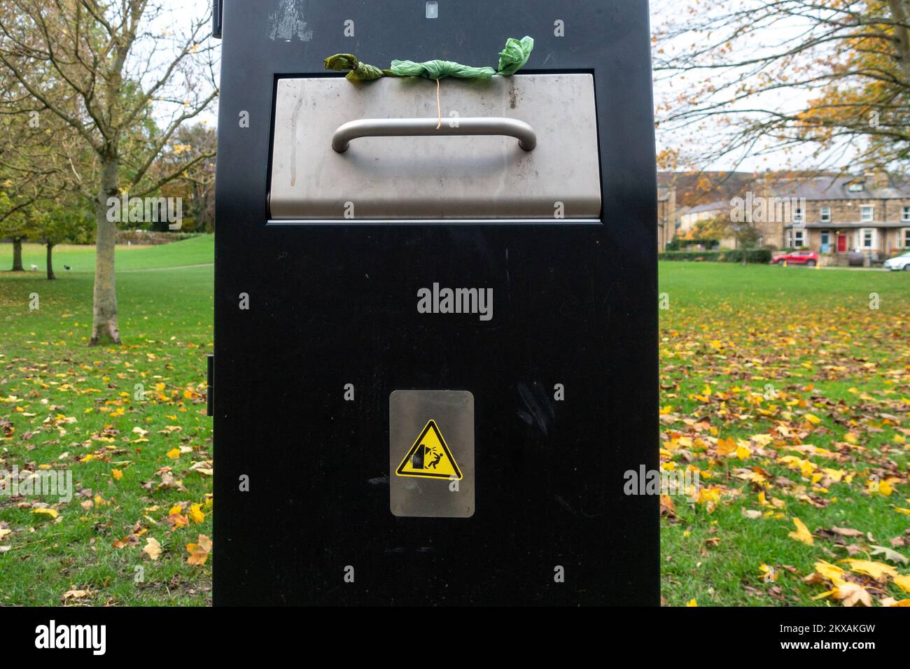 Primo piano di un grande contenitore del poo del cane in un parco in Ikley con un segno divertente circa che batte voi testa. REGNO UNITO Foto Stock