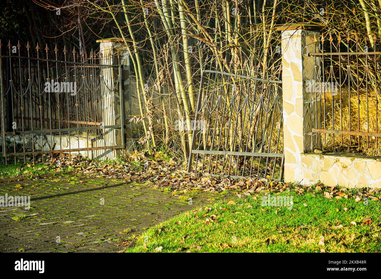 un cancello d'ingresso interrotto abbandonato e recinzione metallica a spioncello, immagine leggermente tonica Foto Stock