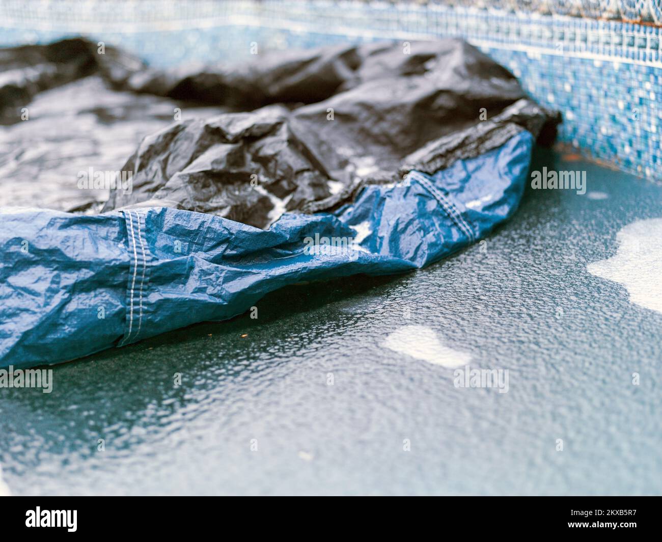 copertura sgualcita per piscina scoperta congelata, ripresa di luce diurna invernale Foto Stock