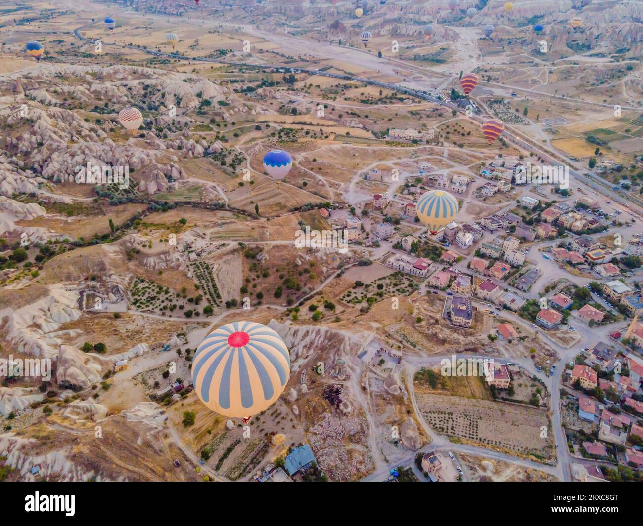 Coloratissime mongolfiere che volano nella valle dei camini delle fate a Nevsehir, Goreme, Cappadocia Turchia. Spettacolare vista panoramica del drone Foto Stock