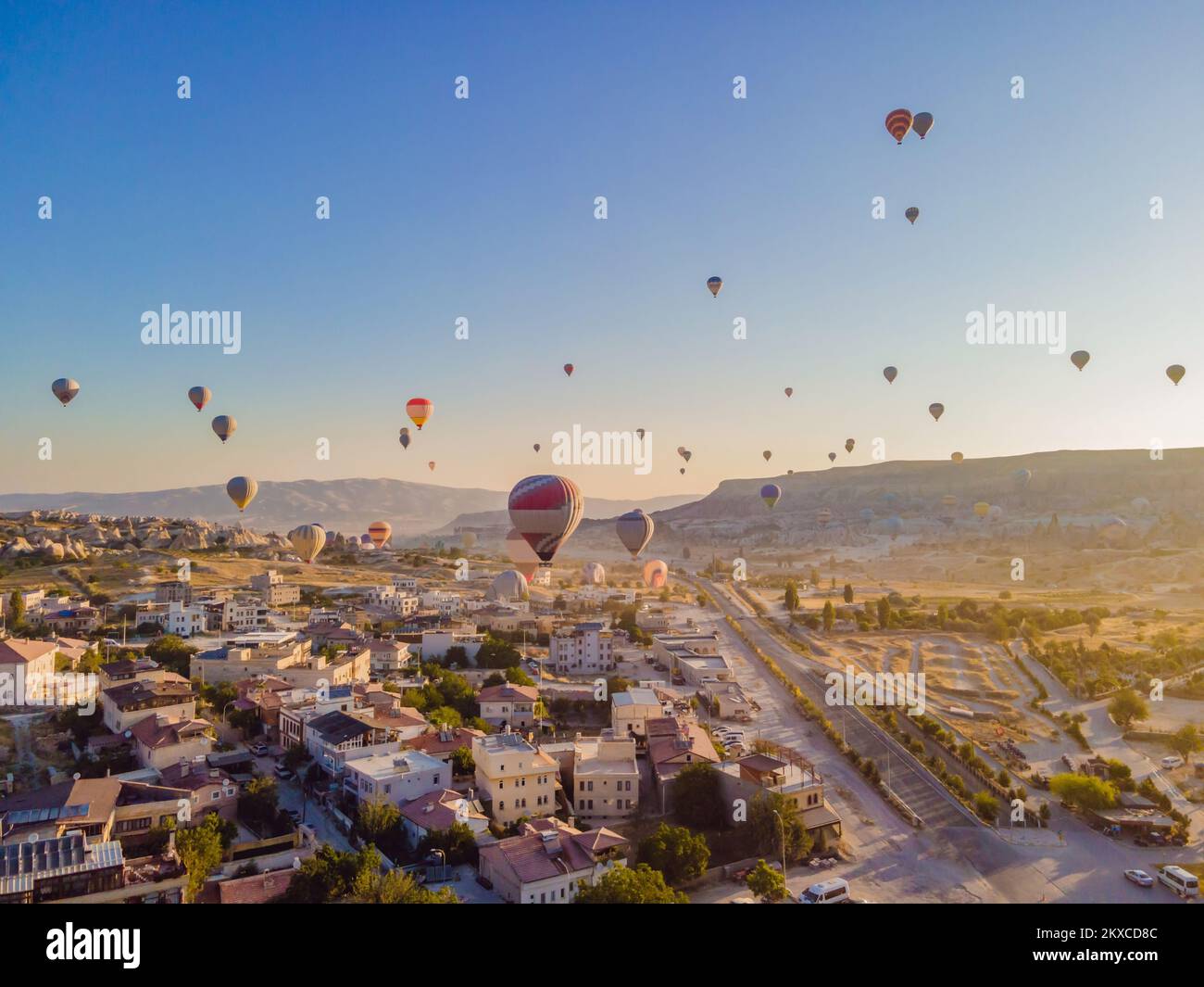 Coloratissime mongolfiere che volano nella valle dei camini delle fate a Nevsehir, Goreme, Cappadocia Turchia. Spettacolare vista panoramica del drone Foto Stock