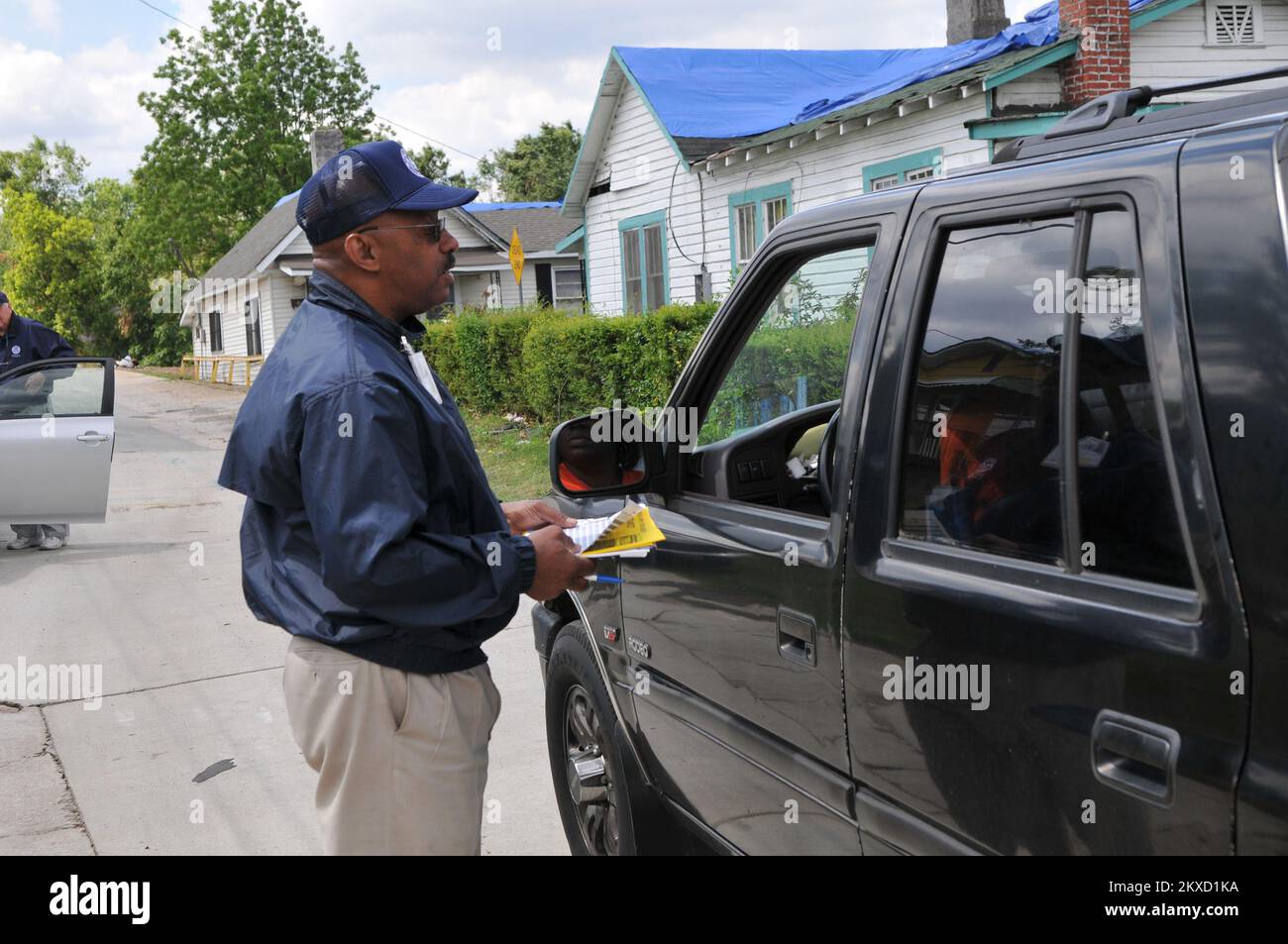 Tornado - Pratt City, Alah. , 17 maggio 2011 FEMA Community Relations Specialist (CR) Erthel Hines risponde alle domande di un sopravvissuto sul processo di registrazione mentre fuori a canvassing il quartiere. CR sta andando porta a porta nelle comunità per incoraggiare le persone a registrarsi, distribuire volantini e rispondere alle domande sul processo. Foto FEMA/Tim Burkitt. Alabama forti tempeste, tornado, venti in linea retta, e alluvioni. Fotografie relative a disastri e programmi, attività e funzionari di gestione delle emergenze Foto Stock
