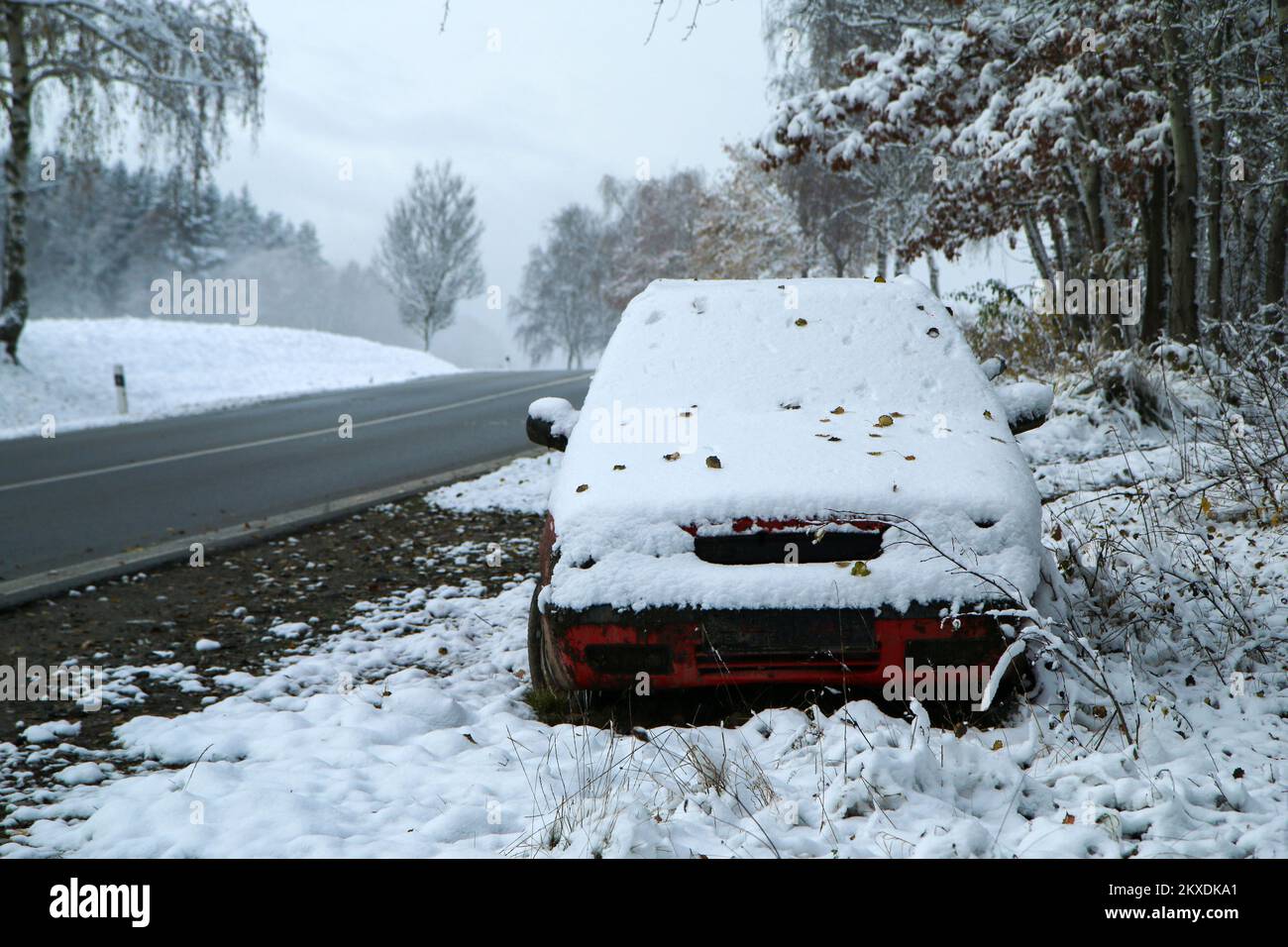 Auto abbandonata in piedi sulla strada. Forse dopo l'incidente stradale o il guasto. Symbolises anche le condizioni pericolose in inverno con ghiaccio, neve e. Foto Stock