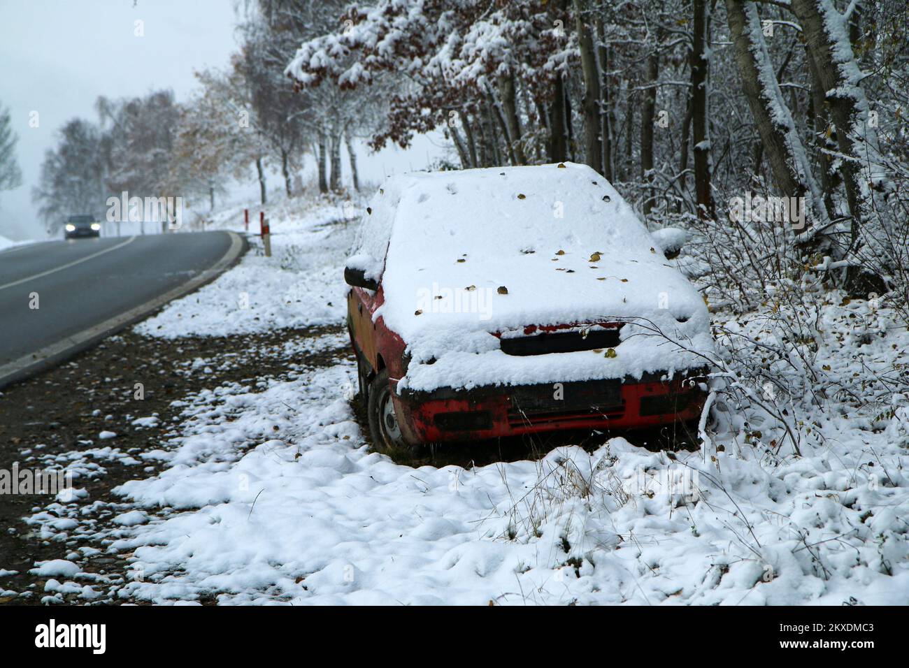 Auto abbandonata in piedi sulla strada. Forse dopo l'incidente stradale o il guasto. Symbolises anche le condizioni pericolose in inverno con ghiaccio, neve e. Foto Stock