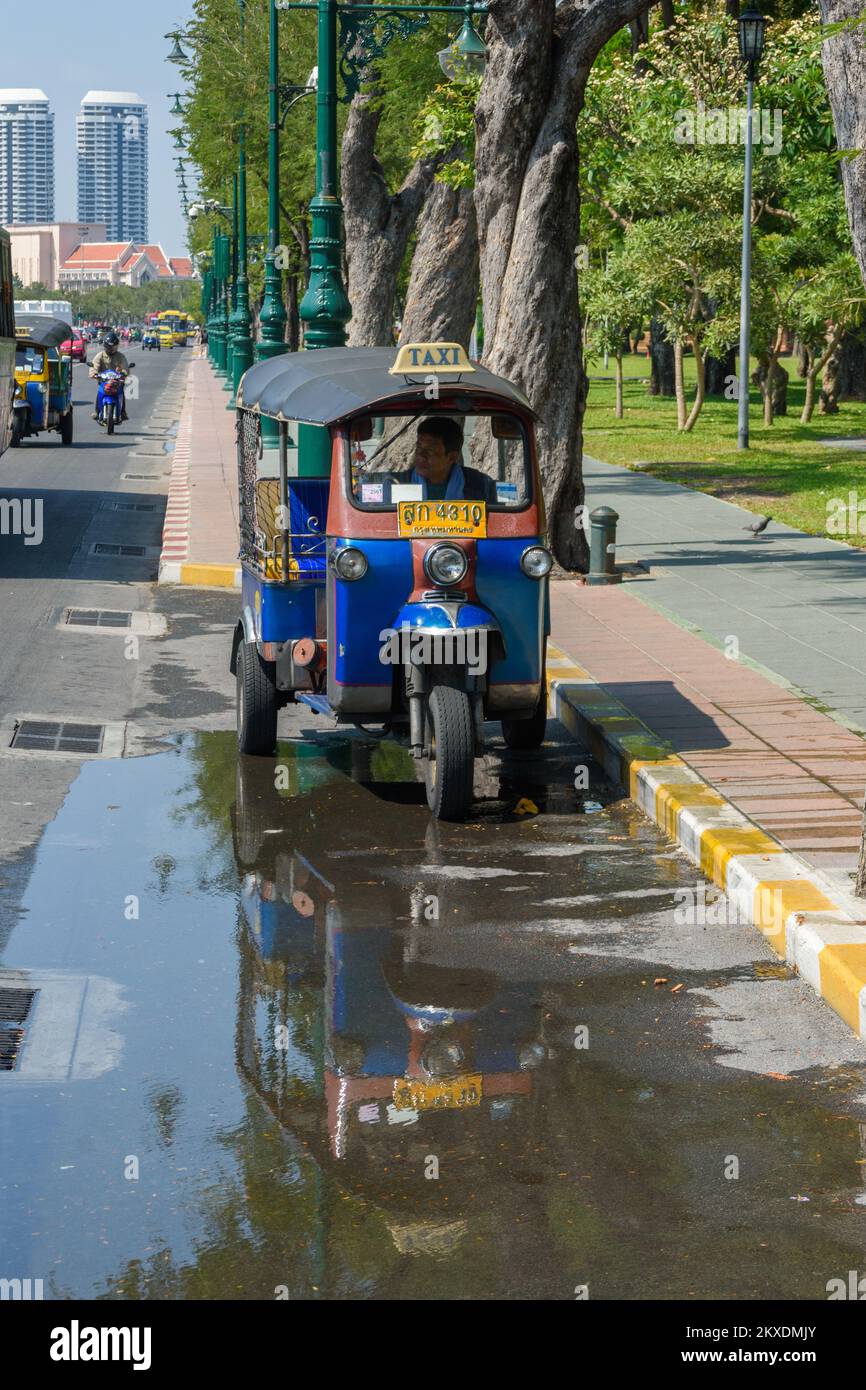 Bangkok, Thailandia - Marzo 19th 2018: Un risciò auto parcheggiato con la sua riflessione su una pozza in Samam Chai Road. Foto Stock