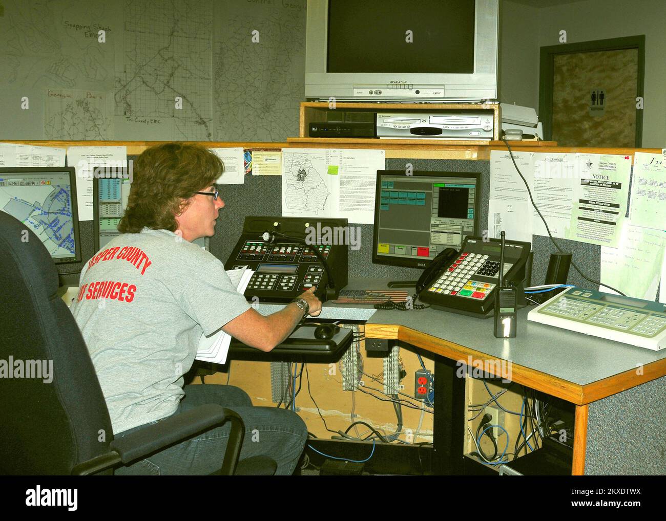 Pianificazione delle emergenze e sicurezza grave tempesta Tornado - Monticello, GA. , 9 giugno 2011 Rachel McInnis, Jasper County 9-1-1 operatore di sistema, è pronto a rispondere a una chiamata di emergenza. Il sistema di allarme di emergenza della contea (unità di attivazione a destra), che ospita anche l'Ufficio di gestione delle emergenze, è situato nel call center in un rifugio fortificato per tempeste. FEMA . Georgia gravi tempeste, tornado, venti in linea retta e le relative alluvioni. Fotografie relative a disastri e programmi, attività e funzionari di gestione delle emergenze Foto Stock