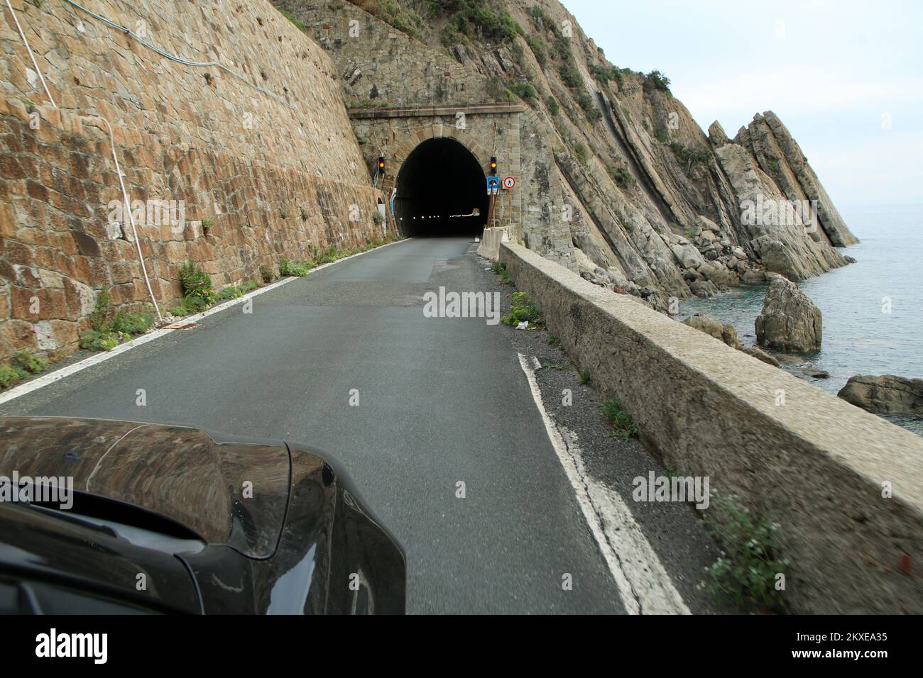 Guidare l'auto verso la stretta costa tunnel di sola andata sulla strada delle Gallerie vicino a Sestri Levante in Italia durante il viaggio di vacanza. Foto Stock