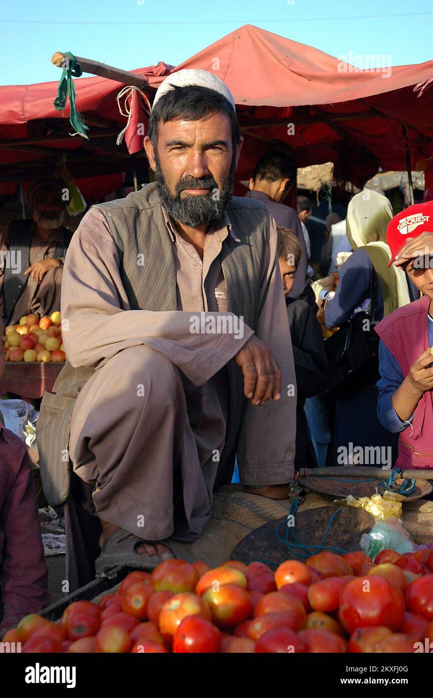 Kabul / Afghanistan: Un afghano con una barba nera vende pomodori al mercato di Kabul. Foto Stock