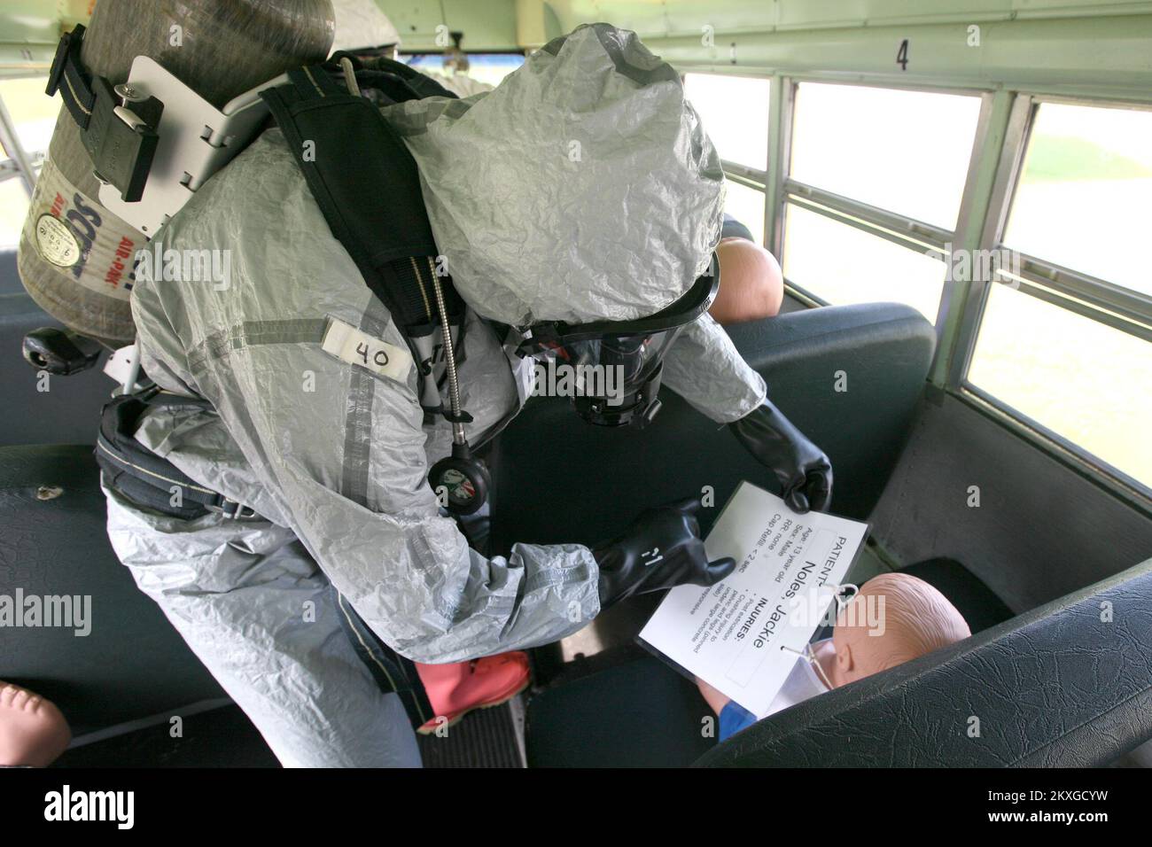 ANNISTON, Ala. , 5 agosto 2011 Un primo soccorritore che arriva ad una scena di incidente simulata che coinvolge un bus della scuola e materiali pericolosi, durante l'addestramento al centro per la preparazione domestica (CDP), legge rapidamente una scheda 'dei sintomi 'per triage correttamente i superstiti potenziali... Fotografie relative a disastri e programmi, attività e funzionari di gestione delle emergenze Foto Stock