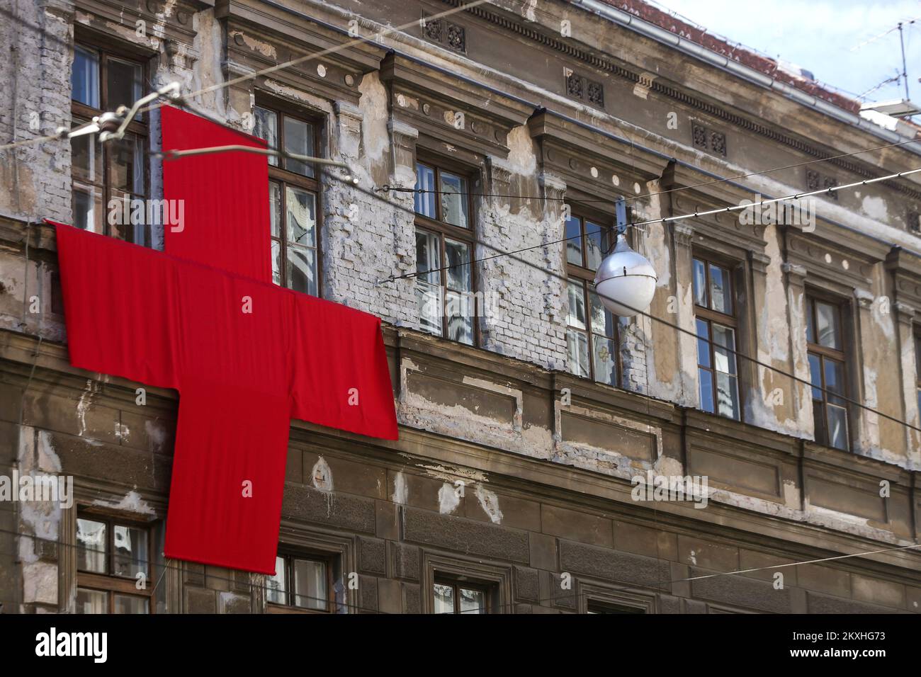 Una croce di tela rossa di 5 Ã— 5 metri è posta sulla parte anteriore di un edificio in via Ilica a Zagabria, Croazia il 4 settembre 2020. Nel corso di dieci giorni, l'autore dell'azione artistica, Aleksandar Battista, vuole motivare i cittadini a pensare alla profondità e alla portata della crisi, ma anche ad attivarsi in direzione di sforzi congiunti per 'guarire' e un nuovo, migliore inizio per la città a tutti i livelli. Foto: Marin Tironi/PIXSELL Foto Stock