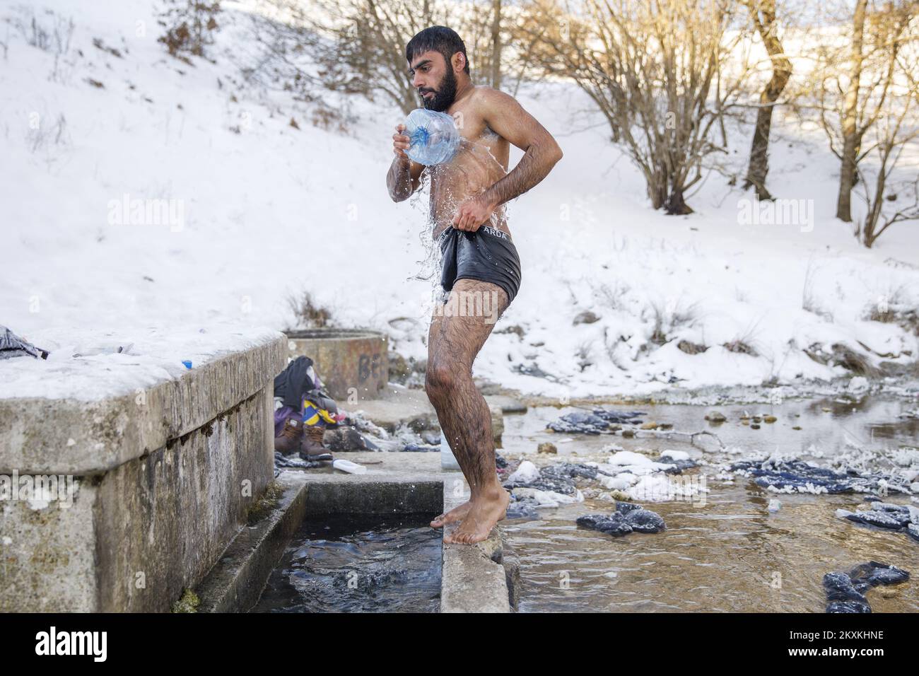 Un migrante dal Pakistan Hagiaz Abdulrehman si pulisce in un flusso nel campo migrante Lipa, vicino Bihac, Bosnia-Erzegovina, il 15 gennaio 2021. L'acqua nei serbatoi si è congelata questa mattina perché la temperatura alle ore 9 era di -14 gradi Celsius. Il Camp Lipa sarà completamente funzionale in 3 mesi. Foto: Armin Durgut/PIXSELL Foto Stock