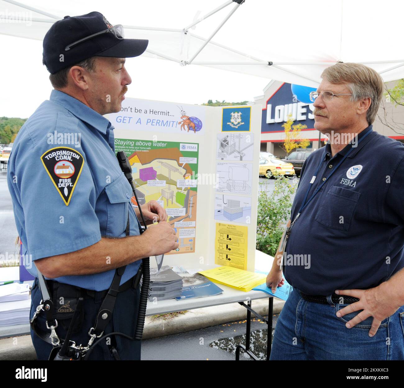 Uragano/tempesta tropicale - Torrington, Conn , 24 settembre 2011 pompiere locale, Andrew Corjulo, a sinistra, Parla con gli specialisti FEMA Community Education e Outreach Steven Klein, durante una giornata in famiglia nel parcheggio del Lowe. I rappresentanti della FEMA hanno distribuito informazioni sulle tecniche di mitigazione per prevenire e mitigare i danni futuri causati da tempeste e disastri naturali. Torrington, CT, 24 settembre 2011--pompiere locale, Andrew Corjulo, A sinistra, parla con la FEMA Community Education e gli Specialisti dell'Outreach Steven Klein, durante una giornata in famiglia nel parcheggio del Lowe. FEMA r Foto Stock
