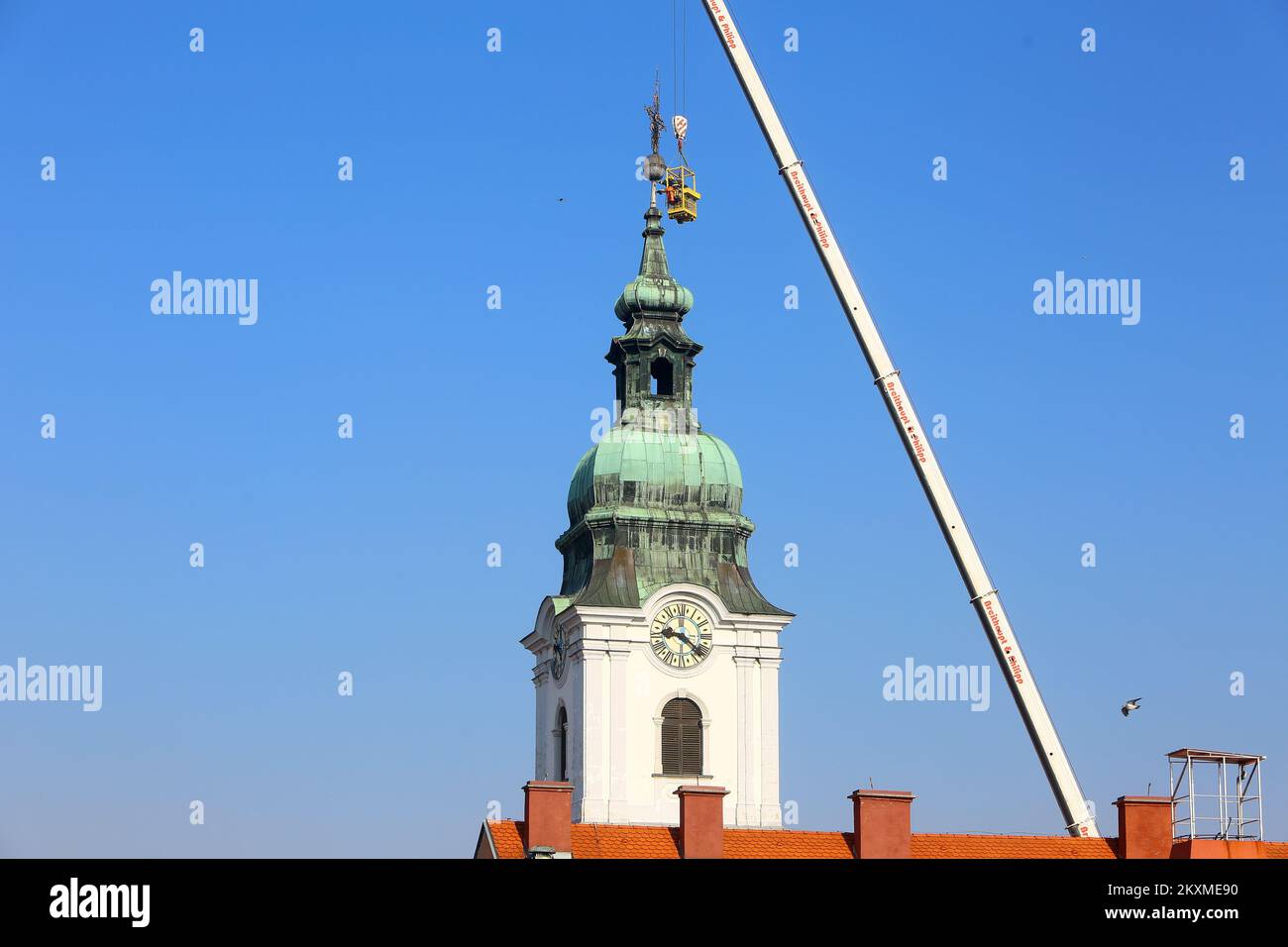 Rimozione del barometro a croce dorato e delle mele dalla Chiesa della Santa Trinità a Karlovac, Croazia il 2 marzo 2021. A causa dei danni subiti dopo il terremoto, il barometro trasversale e una mela del peso di circa 400 chilogrammi sono stati rimossi dal campanile della chiesa più antica di Karlovac. La crisi ha 230 anni, e i vigili del fuoco hanno partecipato all'azione per rimuovere la crisi con l'aiuto di una gru da 60 tonnellate. Solo alcune città austro-ungarche avevano un barometro a croce, e Karlovac è stato tra loro fino ad oggi. Foto: Kristina Stedul Fabac/PIXSELL Foto Stock