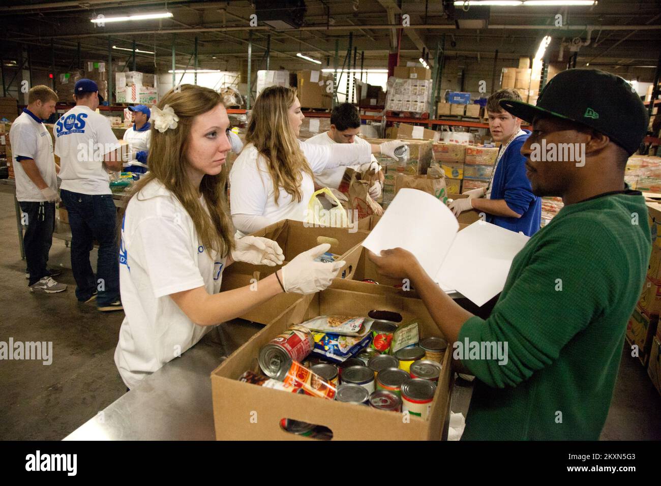 Alluvione uragano/tempesta tropicale - Hillside, N. J., 5 novembre 2011 Cara Caroccio (a sinistra), un volontario del Seton Hall University Service il sabato (SOS), e Khalief Fitzgerald (a destra) ordinare e confezionare il cibo donato presso la Community Food Bank del New Jersey. La Food Bank è un membro dello stato di Feeding America, un'organizzazione nazionale che è un membro delle organizzazioni nazionali di volontariato attivo in disastri (VOAD). Uragano Irene del New Jersey. Fotografie relative a disastri e programmi, attività e funzionari di gestione delle emergenze Foto Stock