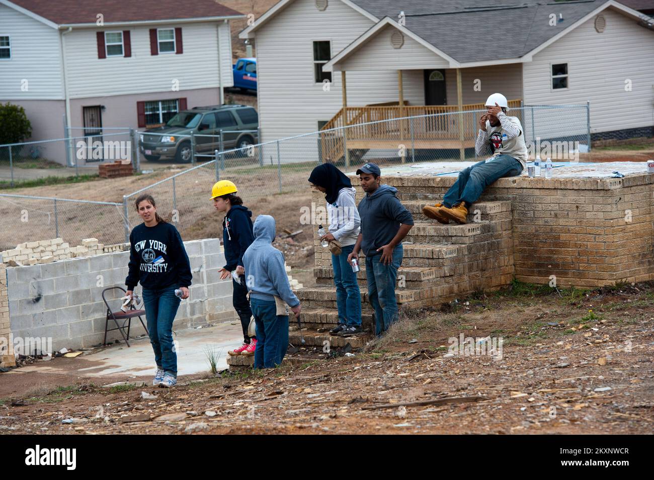 Tornado - Pratt City, Alah. , 17 gennaio 2012 volontari ebrei e musulmani degli studenti della NYU fare una breve pausa in un luogo di lavoro dove 2 nuove case sono in costruzione per i sopravvissuti al tornado. Il finanziamento FEMA e il coordinamento con le agenzie di volontariato hanno contribuito a far sì che ciò avvenisse. Foto FEMA/Tim Burkitt. Alabama forti tempeste, tornado, venti in linea retta, e alluvioni. Fotografie relative a disastri e programmi, attività e funzionari di gestione delle emergenze Foto Stock