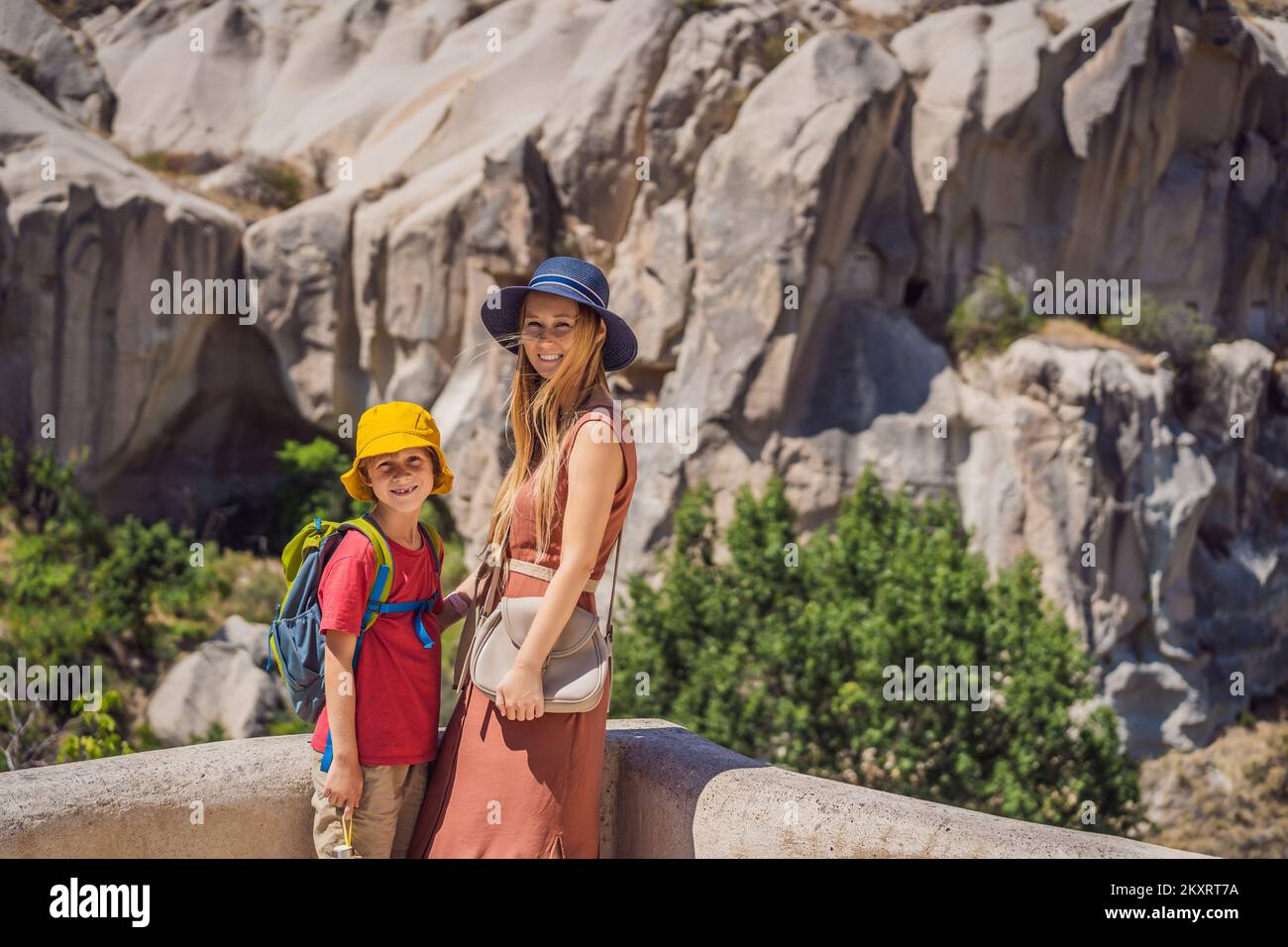 Mamma e figlio turisti esplorando la valle con formazioni rocciose e grotte delle fate vicino a Goreme in Cappadocia Turchia Foto Stock